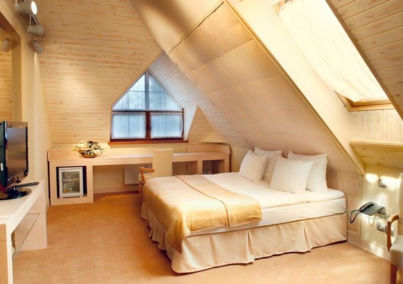 Уютная спальня в ванильно-бежевых тонах на крыше дома