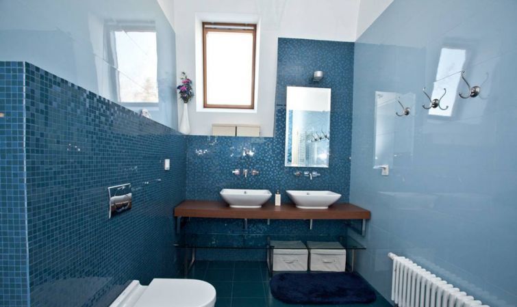 Дизайн ванной комнаты в сочетании синей мелкой плитки и глянцевых серых стен.