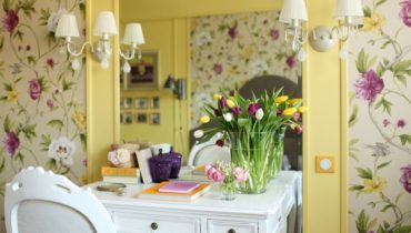 Цветочные обои с пастельно-желтыми вставками и белым письменным столиком.