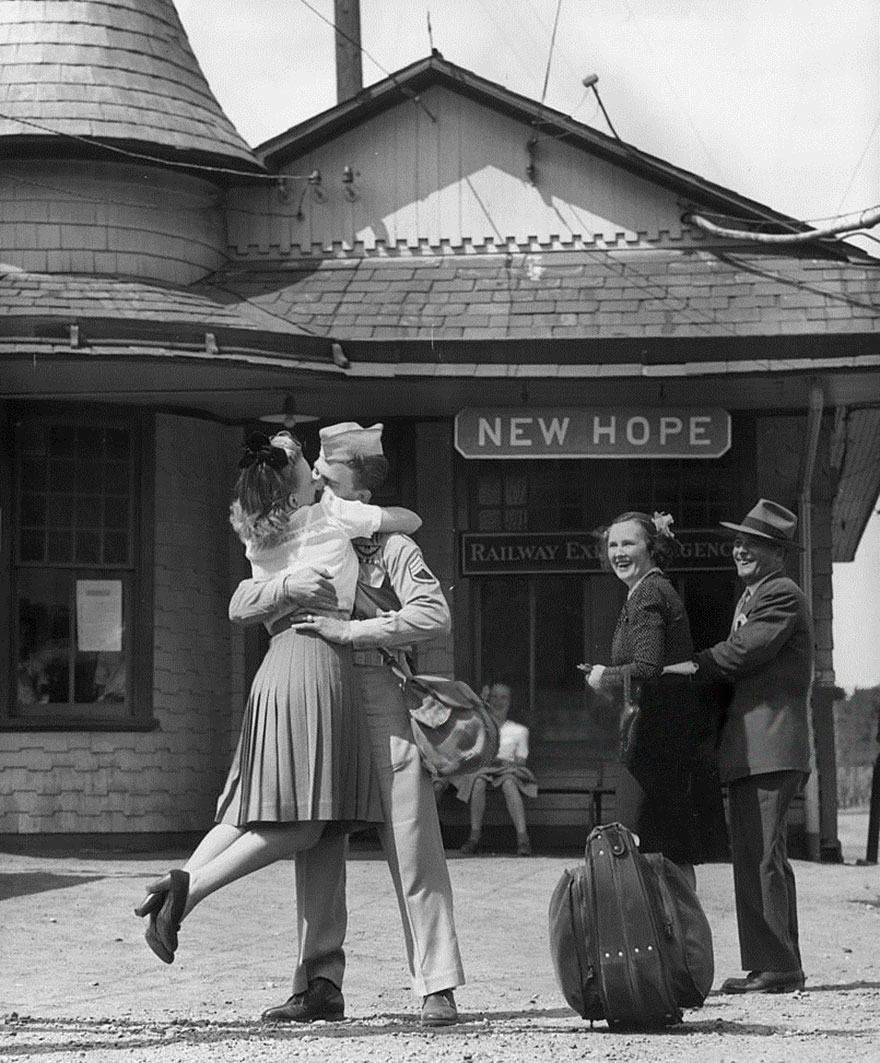 4. Молодая девушка, подняв ноги, обнимает и целует американского солдата на вокзале, Коннектикут, 1945 год 