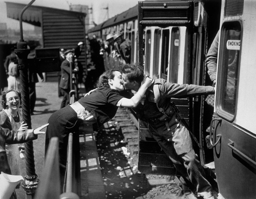 6. Историческая фотография, где женщина склонясь над порученем, целует британского солдата, возвращающегося со Второй мировой войны, Лондон, 1940 год