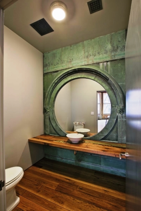 1. Оригинальный дизайн туалета с большим круглым зеркалом и деревянным полом 