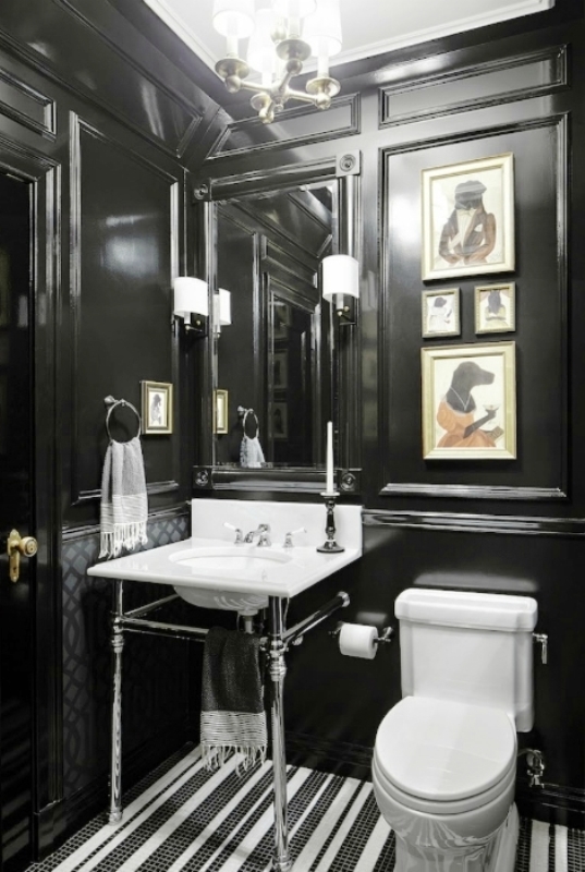 4. Необычный интерьер туалета черного цвета с креативными картинами и белым унитазом и умывальником 