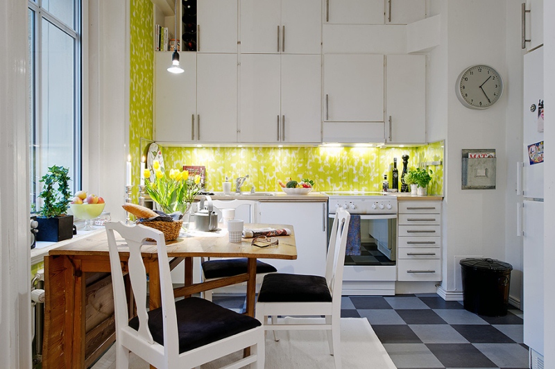 Необычный фартук с освещением ярко-салатового цвета, геометрические шкафчики и шахматный пол в дизайне кухни