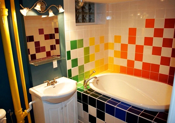 8. Разноцветная плитка, желтые трубы и умывальник в винтажном стиле в интерьере ванной комнаты