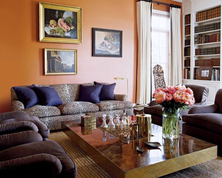 Стильная гостиная в классическом стиле с дорогими картинами, низким столиком и мягкой мебелью