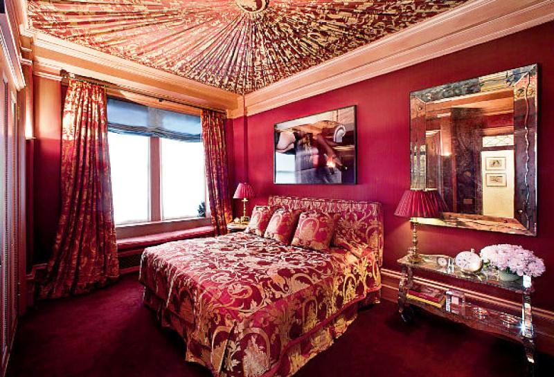 Роскошна спальня в красных тонах с широкой кроватью и необычным потолком