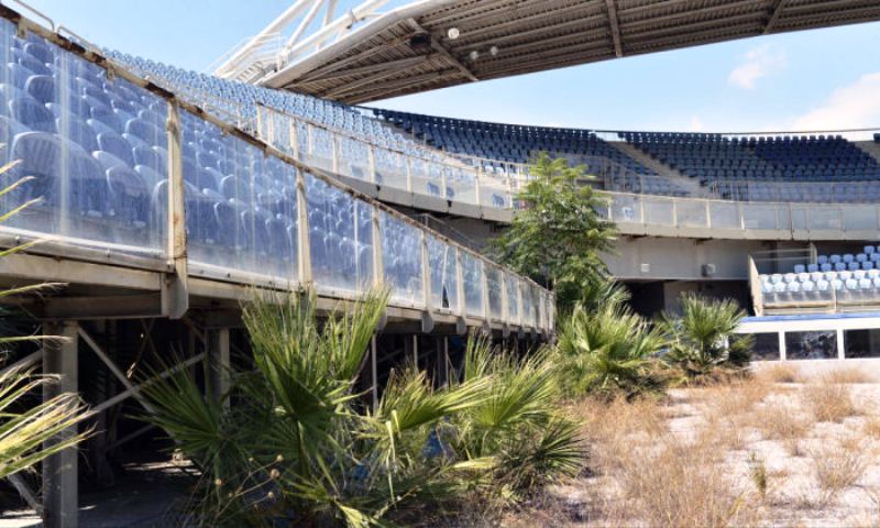 Заброшенный стадион для пляжного волейбола, заросший растениями.