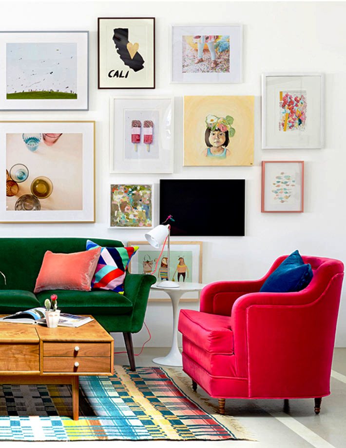 Необычайно яркий интерьер с зеленым и розовым диванчиками, множеством разноцветных картин и старинным журнальным столиком