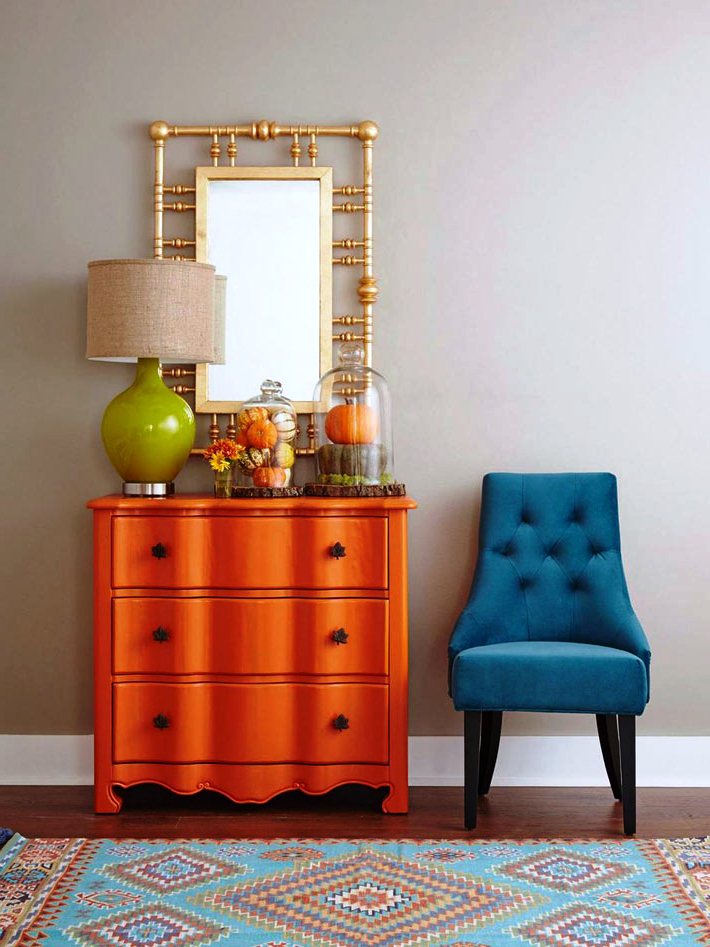 Оранжевый комод с зеркалом, синий мягкий стульчик и салатовый светильник: стильно и лаконично