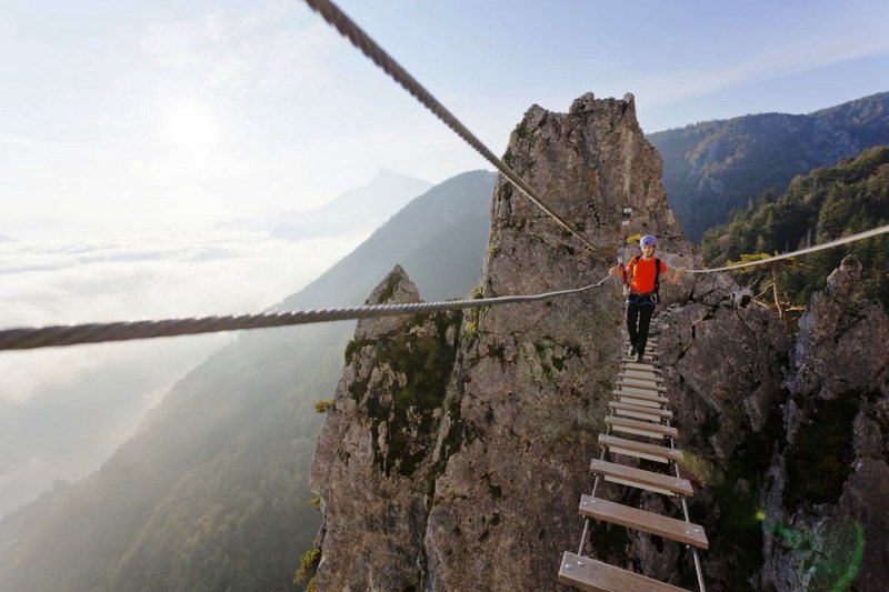 Экстримальная девушка на веревочном мосте. Драконова стена, озеро Мондзее, Австрия